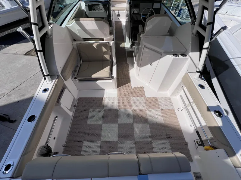 Slide: The Image of 2016 Pursuit DC 295 Dual Console boat interior with clean seating and checkered flooring. - 27