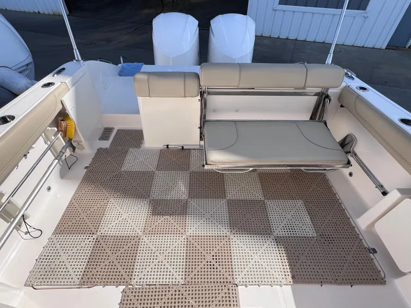 Slide: The Image of 2016 Pursuit DC 295 boat interior with beige seating and checkered floor mat. - 29