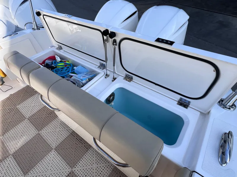 Slide: The Image of 2016 Pursuit DC 295 boat storage compartments with twin Yamaha 300 engines. - 30