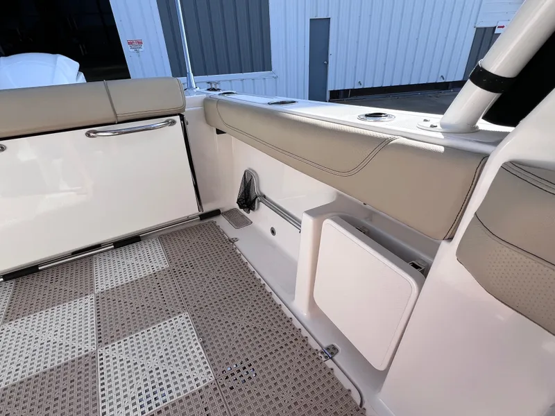 Slide: The Image of 2016 Pursuit DC 295 boat interior with beige seating and checkered flooring. - 32