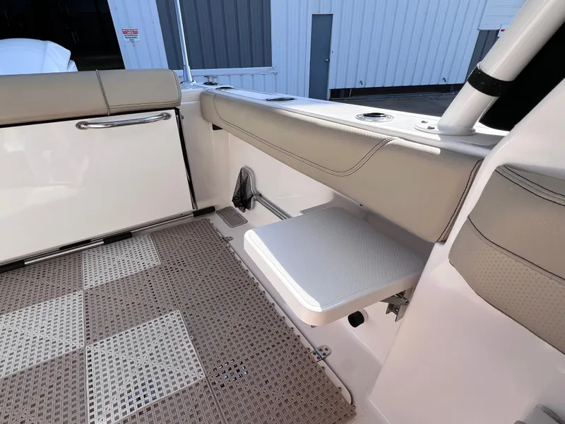 Slide: The Image of 2016 Pursuit DC 295 boat interior with beige seating and non-slip flooring. - 33