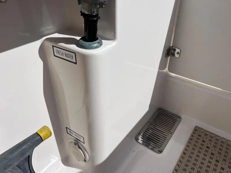 Slide: The Image of Freshwater outlet on 2016 Pursuit DC 295 Dual Console boat, featuring clean design. - 35