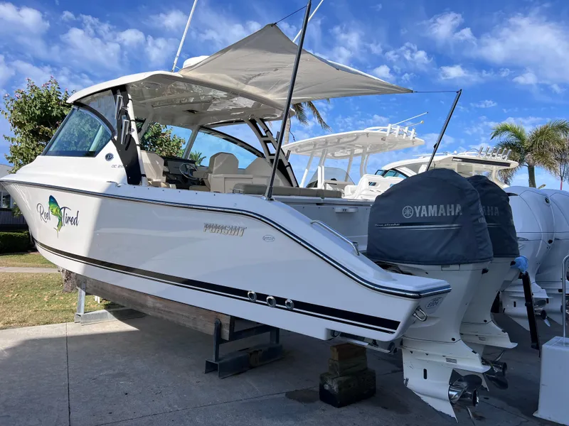 Slide: The Image of 2016 Pursuit DC 295 Dual Console boat with twin Yamaha 300 engines, docked outdoors. - 9