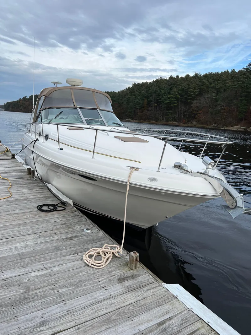 Slide: The Image of 1999 Sea Ray 340 Sundancer docked by a serene lake with forested background. - 1