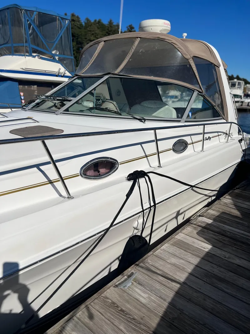 Slide: The Image of 1999 Sea Ray 340 Sundancer docked, showcasing sleek design and spacious cabin. - 2