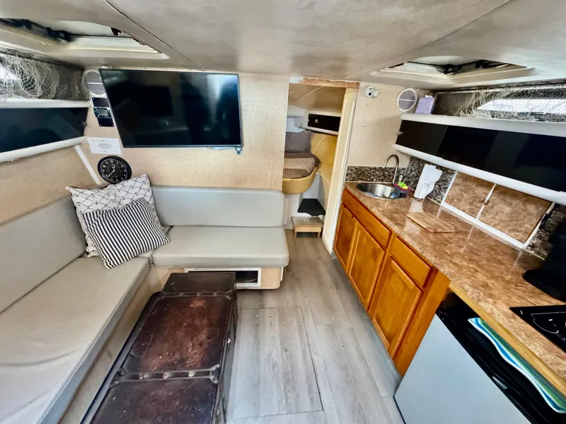 Slide: The Image of Interior of a 1987 Silverton Express boat with seating, kitchenette, and TV. - 6