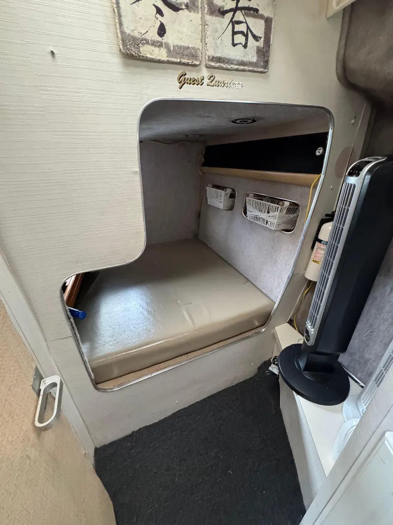 Slide: The Image of 1987 Silverton Express cabin interior with a cozy sleeping area and storage baskets. - 9