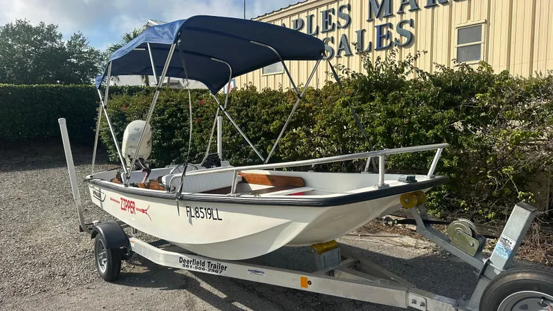 Slide: The Image of 1971 Boston Whaler 13 Sport boat on trailer with blue canopy, parked outdoors. - 1