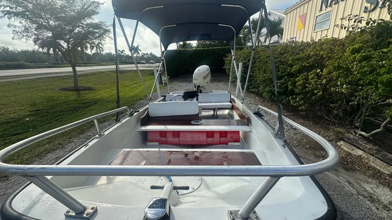 Slide: The Image of 1971 Boston Whaler 13 Sport boat with canopy, parked outdoors. - 4