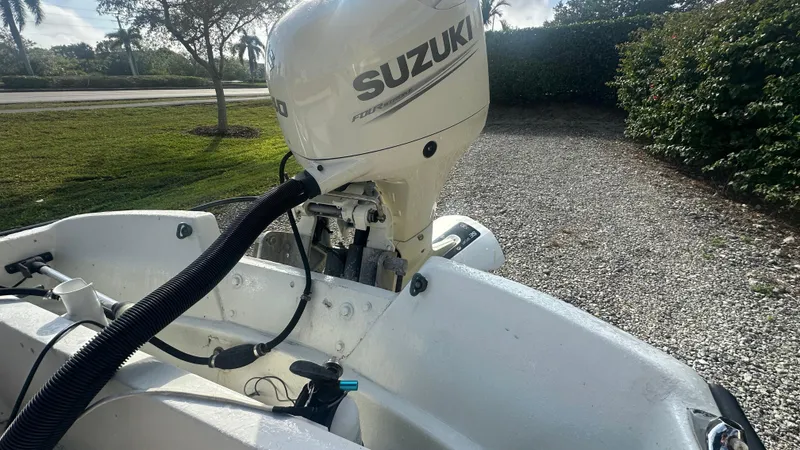 Slide: The Image of 1971 Boston Whaler 13 Sport with Suzuki outboard motor, parked on gravel driveway. - 6