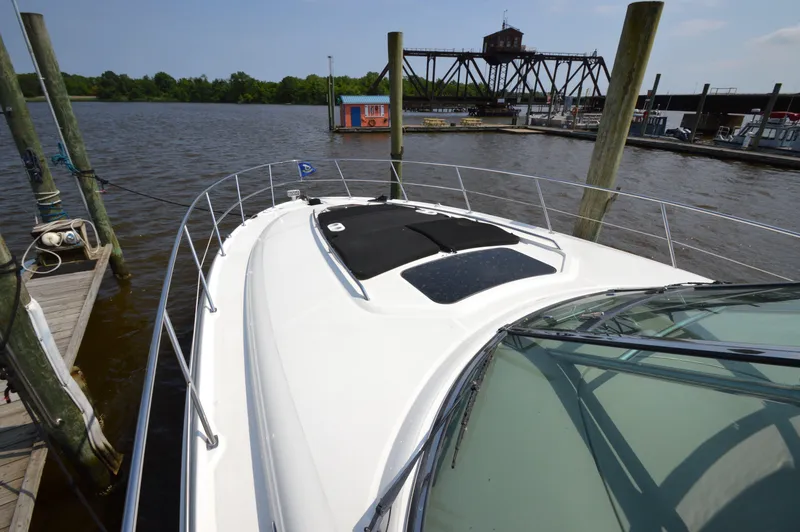 Slide: The Image of 2007 Sea Ray 44 Sundancer yacht docked by a river with scenic background. - 11