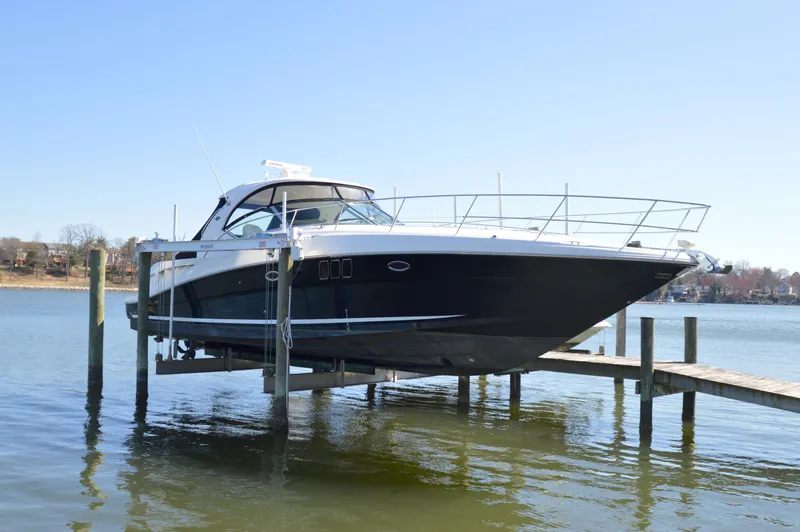 Slide: The Image of 2007 Sea Ray 44 Sundancer yacht docked on a lift over calm water. - 3