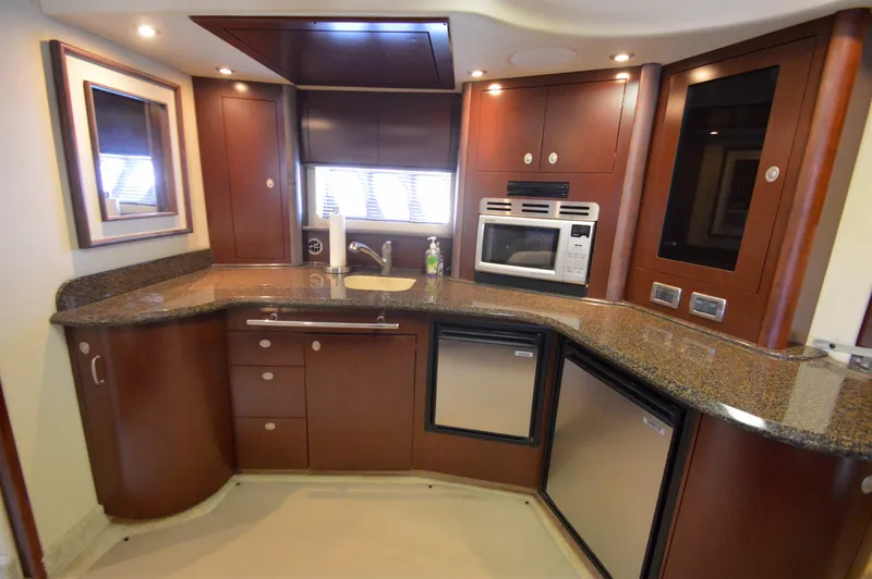 Slide: The Image of Luxurious 2007 Sea Ray 44 Sundancer yacht kitchen with modern appliances and elegant wood cabinetry. - 34