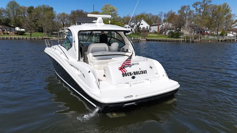 Slide: The Image of 2007 Sea Ray 44 Sundancer yacht on a scenic waterway with American flag. - 6