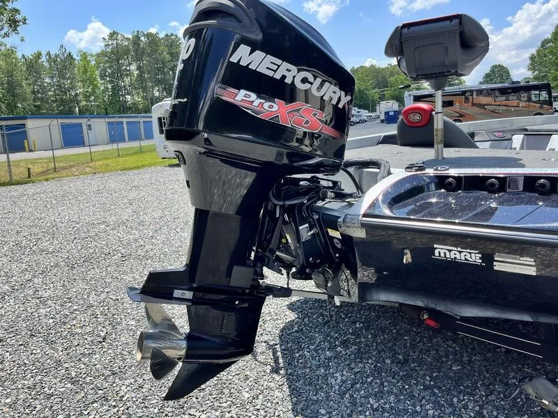 Slide: The Image of 2014 Ranger Z118 Comanche with Mercury Pro XS outboard motor in a gravel lot. - 11