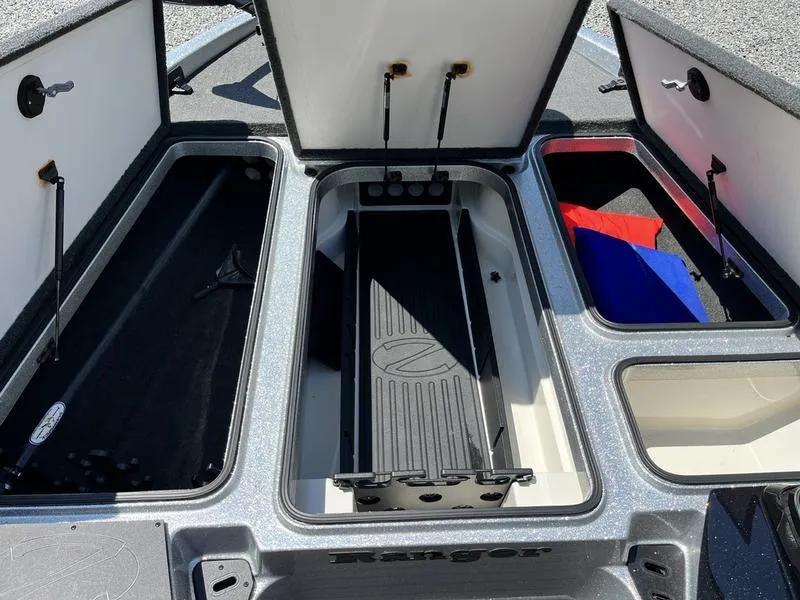 Slide: The Image of 2014 Ranger Z118 Comanche boat storage compartments open, showcasing interior space. - 18