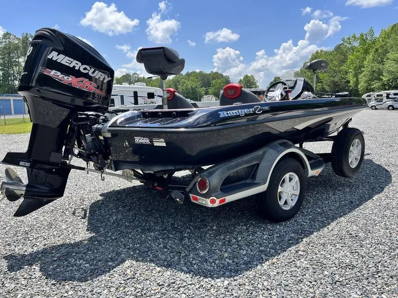 Slide: The Image of 2014 Ranger Z118 Comanche boat with Mercury engine on a trailer, parked outdoors. - 3