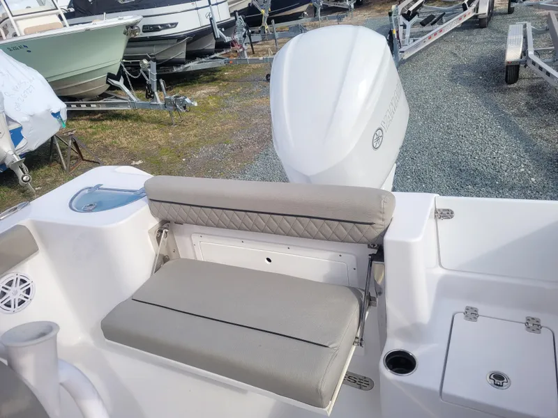 Slide: The Image of 2023 Sportsman Open 232 Center Console boat with cushioned seating and outboard motor. - 10