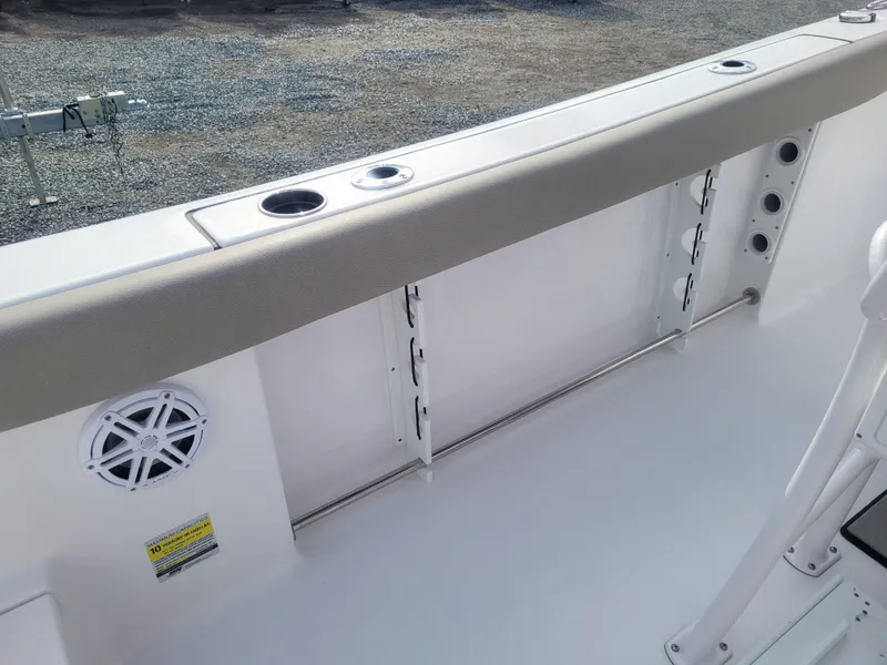 Slide: The Image of 2023 Sportsman Open 232 Center Console boat interior with rod holders and speaker. - 12