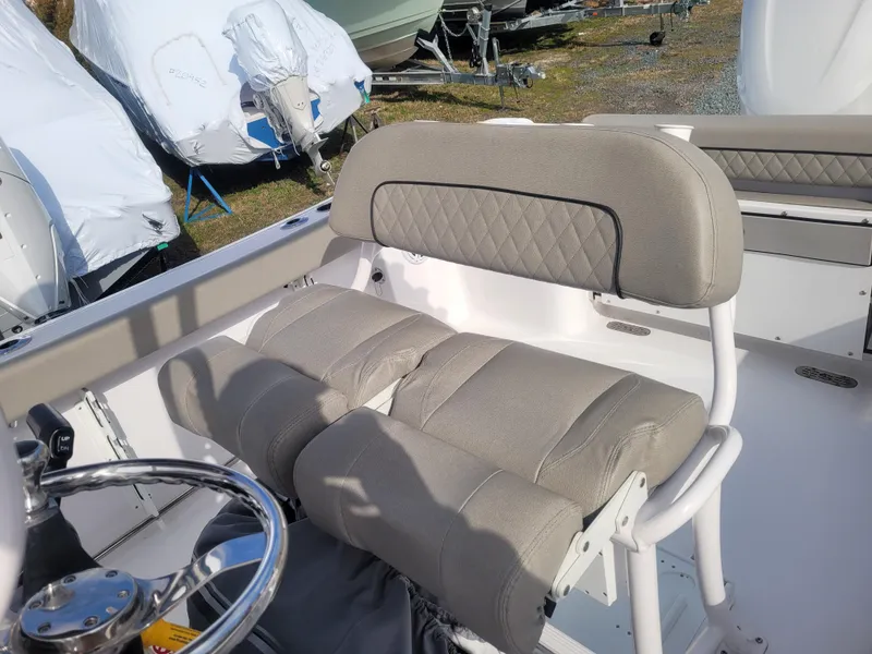 Slide: The Image of 2023 Sportsman Open 232 Center Console boat with cushioned seating and steering wheel. - 16