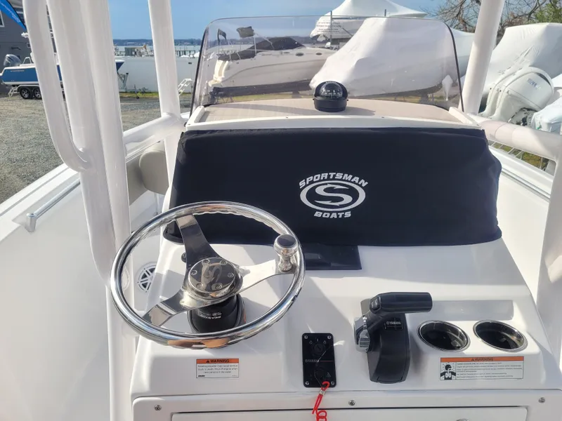 Slide: The Image of 2023 Sportsman Open 232 Center Console boat dashboard with steering wheel and controls. - 19