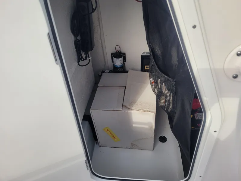 Slide: The Image of Storage compartment of 2023 Sportsman Open 232 Center Console boat with equipment and a box. - 22