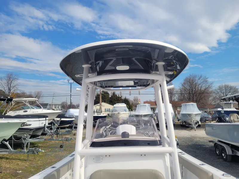 Slide: The Image of 2023 Sportsman Open 232 Center Console boat in a marina under a blue sky. - 23