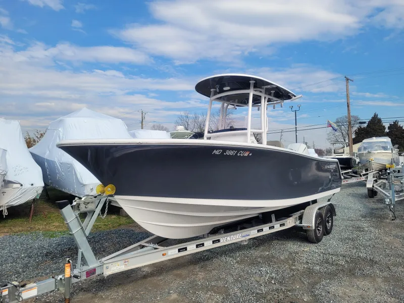 Slide: The Image of 2023 Sportsman Open 232 Center Console boat on trailer under blue sky. - 3