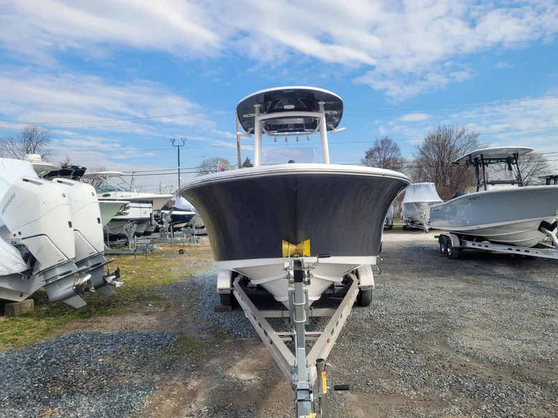 Slide: The Image of 2023 Sportsman Open 232 Center Console boat on trailer, parked outdoors under a blue sky. - 6