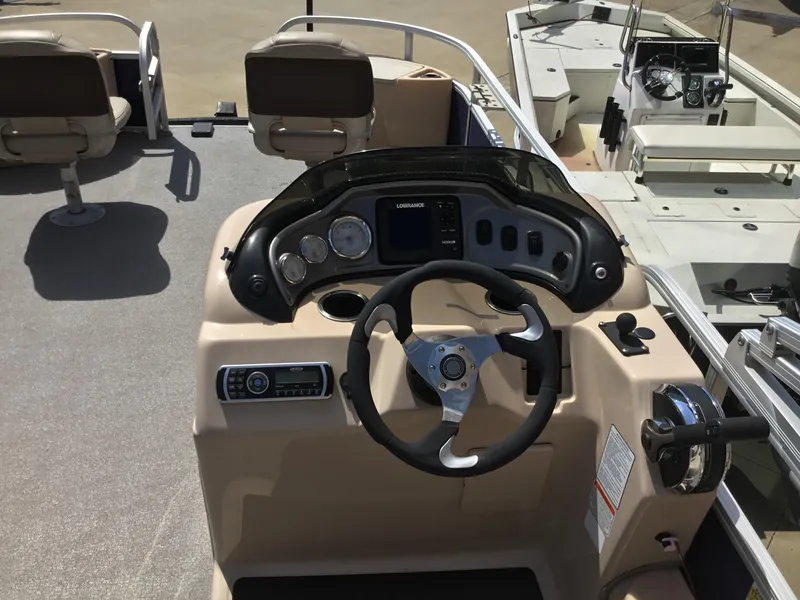 Slide: The Image of 2017 Sun Tracker Fishin' Barge 22 DLX helm with steering wheel and control panel. - 8