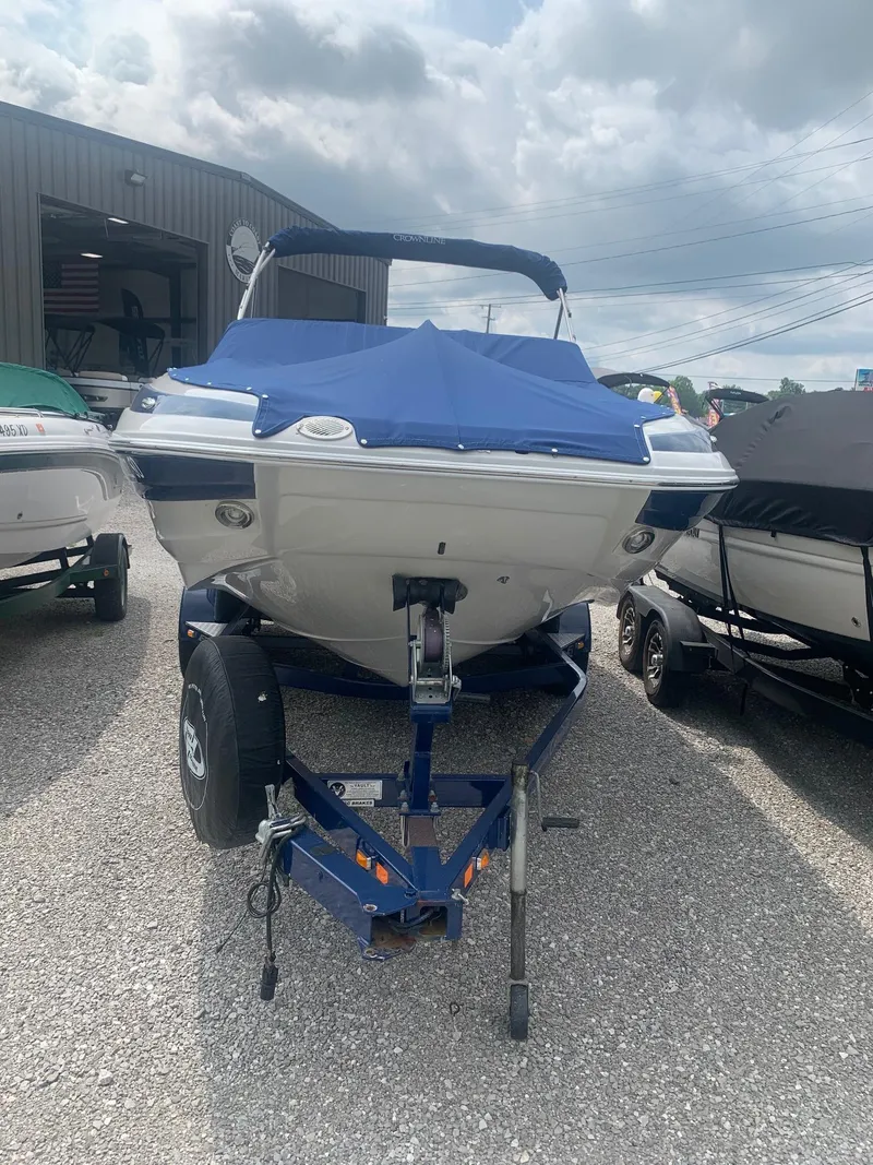Slide: The Image of 2012 Crownline E1EC1Z boat on trailer, covered, parked outdoors. - 2