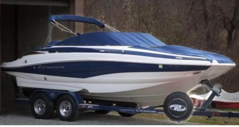 Slide: The Image of 2012 Crownline E1EC1Z boat on trailer, blue and white design, parked outdoors. - 6