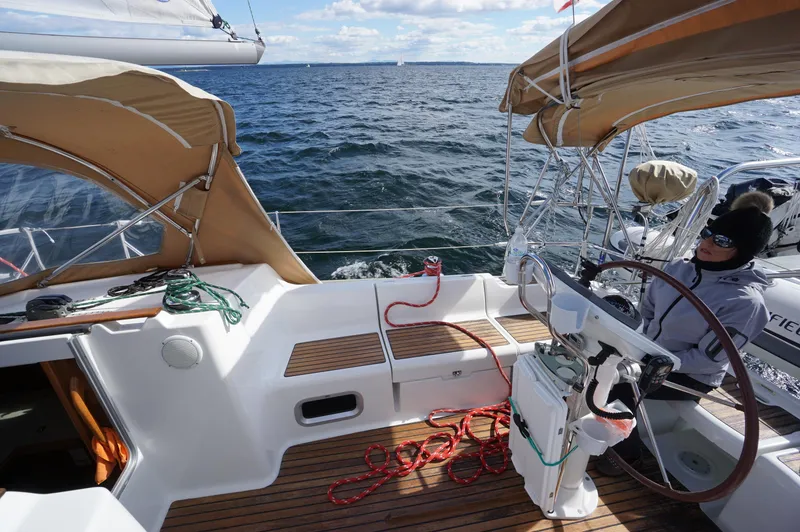 Slide: The Image of 2004 Jeanneau SO 37 sailboat on open water, featuring a spacious cockpit and steering wheel. - 4