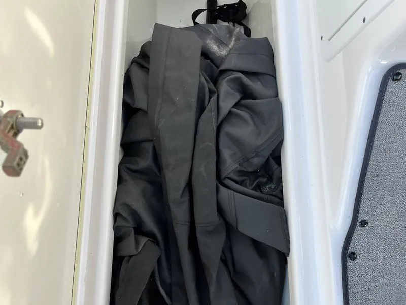 Slide: The Image of Storage compartment in a 2021 Yamaha AR195 boat with a folded black cover. - 13