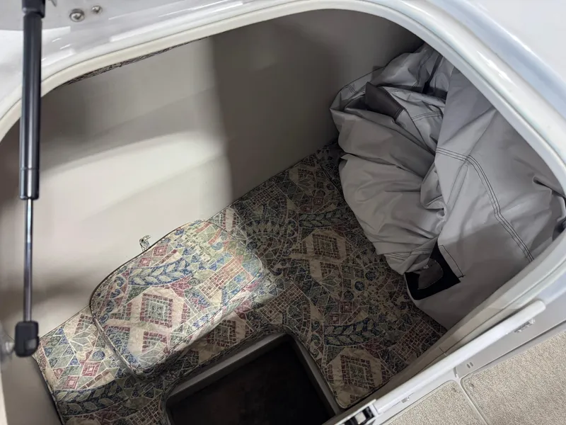 Slide: The Image of Storage compartment in a 2003 Crownline 280 BR boat with patterned flooring and cover. - 10