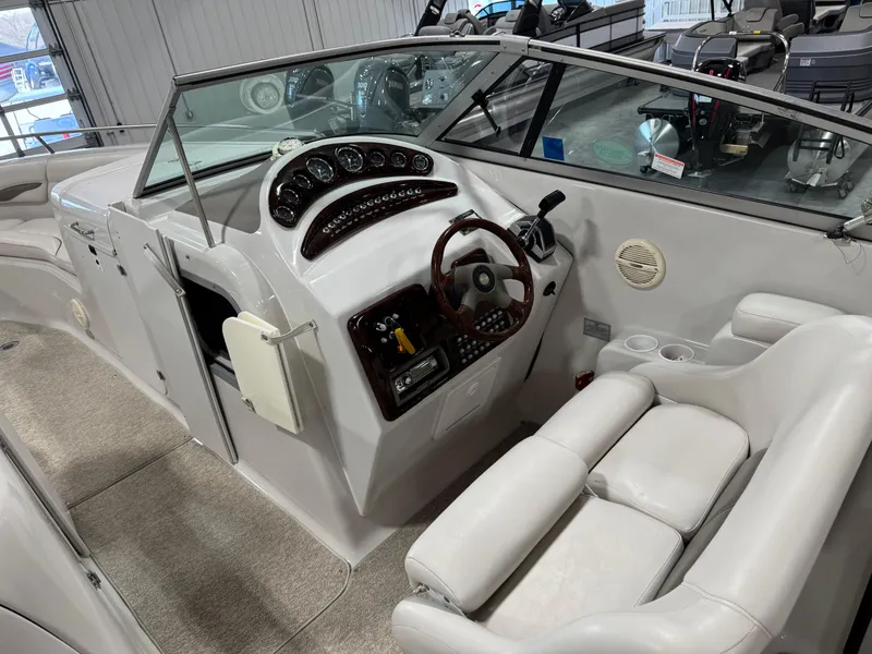 Slide: The Image of 2003 Crownline 280 BR boat interior with steering wheel, dashboard, and seating area. - 14