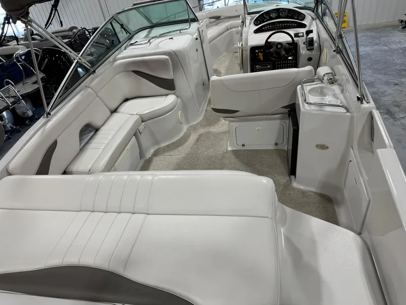 Slide: The Image of 2003 Crownline 280 BR boat interior with white seating and modern dashboard. - 15