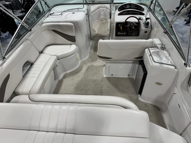 Slide: The Image of 2003 Crownline 280 BR boat interior with white seating and modern dashboard. - 7