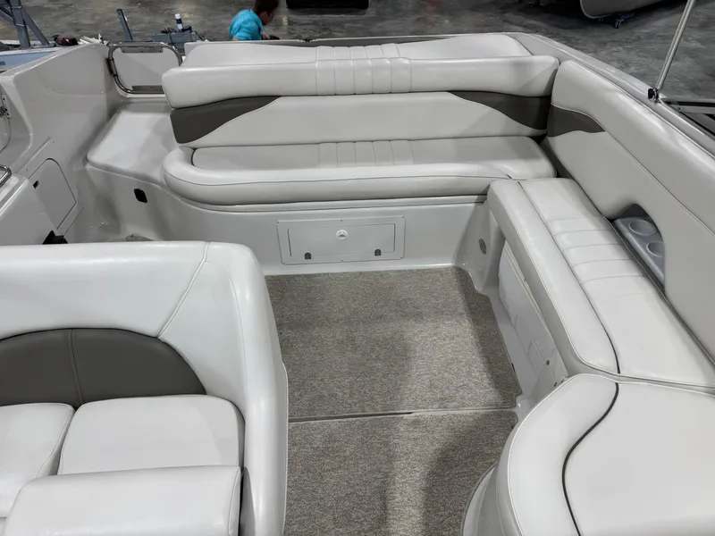 Slide: The Image of 2003 Crownline 280 BR boat interior with white and gray seating, carpeted floor. - 9