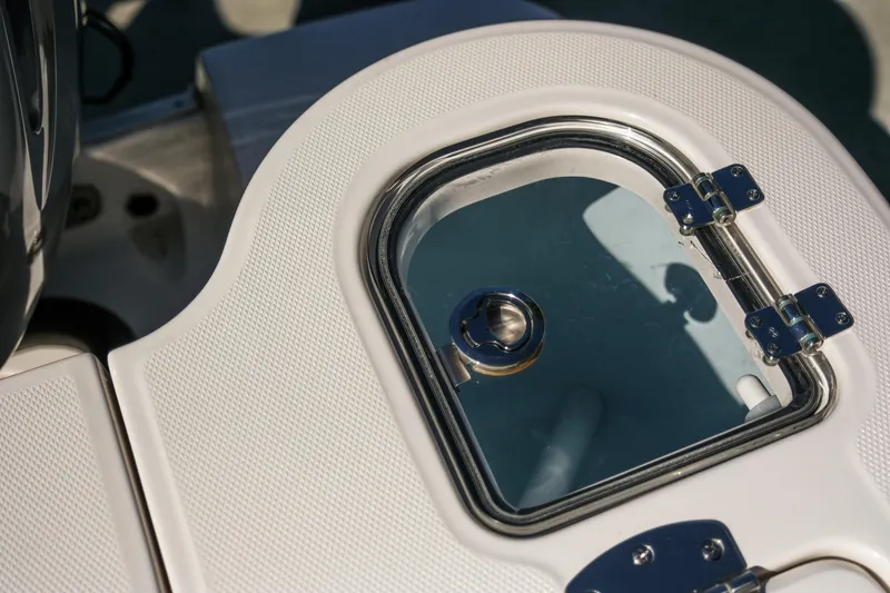 Slide: The Image of 2022 Robalo R247 Dual Console boat hatch detail with stainless steel hinges. - 13