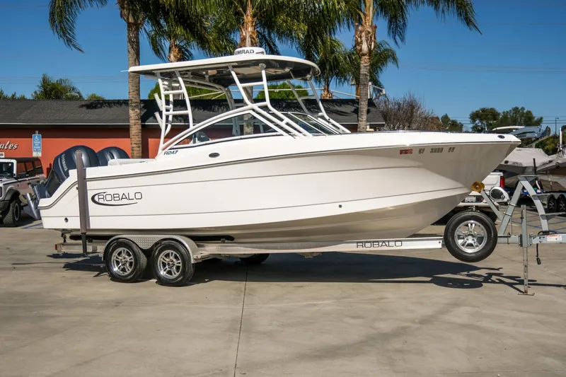 Slide: The Image of 2022 Robalo R247 Dual Console boat on trailer, parked outdoors. - 16