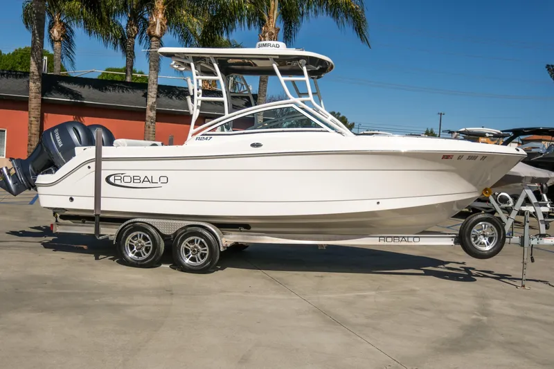 Slide: The Image of 2022 Robalo R247 Dual Console boat on trailer, parked outdoors. - 18