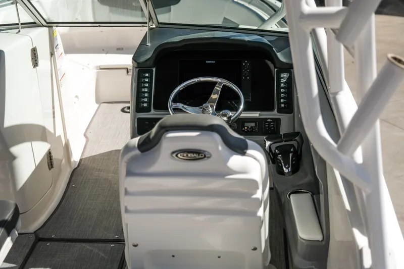 Slide: The Image of 2022 Robalo R247 Dual Console boat interior with steering wheel and dashboard. - 2