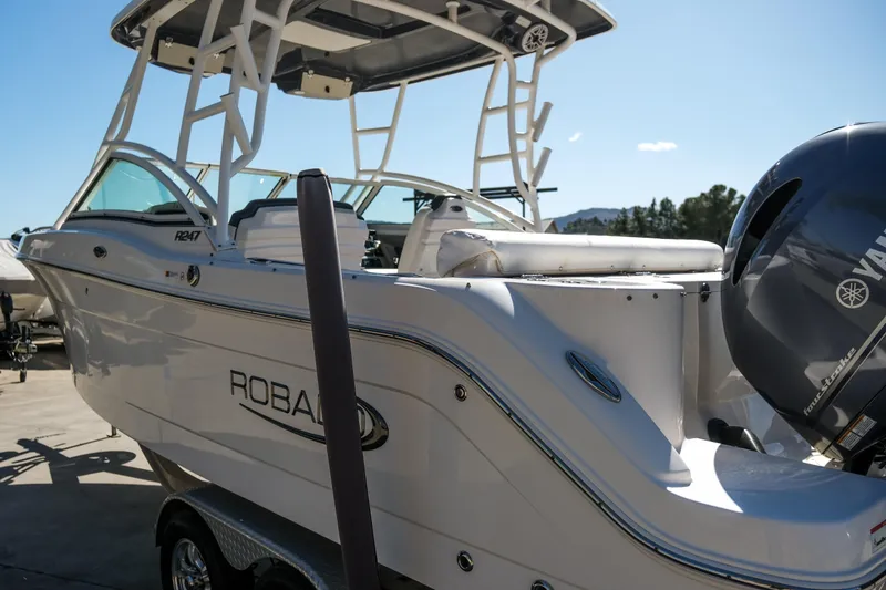 Slide: The Image of 2022 Robalo R247 Dual Console boat with Yamaha engine, docked under clear sky. - 25