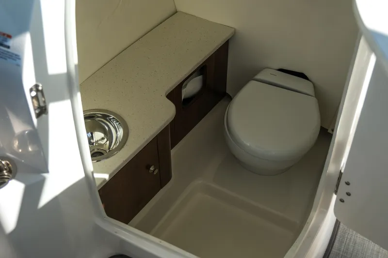Slide: The Image of 2022 Robalo R247 Dual Console boat interior with toilet and sink. - 3