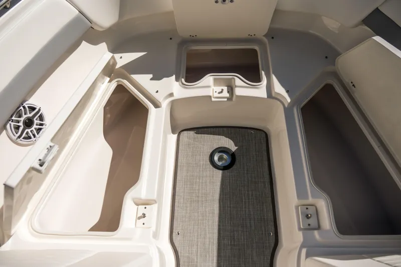 Slide: The Image of 2022 Robalo R247 Dual Console boat interior with storage compartments and speaker. - 6