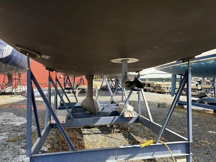 Slide: The Image of Beneteau 45 sailboat hull on stands, 2018 model, in a boatyard setting. - 25