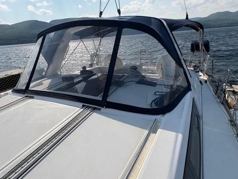 Slide: The Image of 2018 Beneteau Oceanis 45 sailboat with cockpit enclosure on a scenic lake. - 4