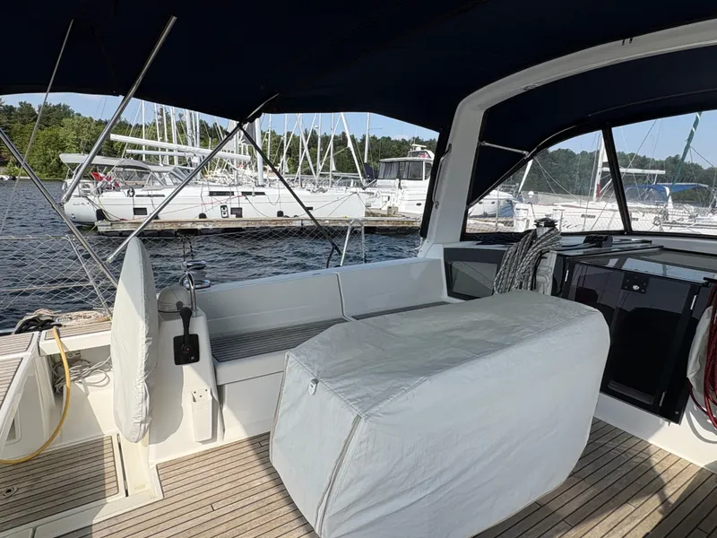 Slide: The Image of 2018 Beneteau Oceanis 45 sailboat cockpit with covered seating, docked at marina. - 8
