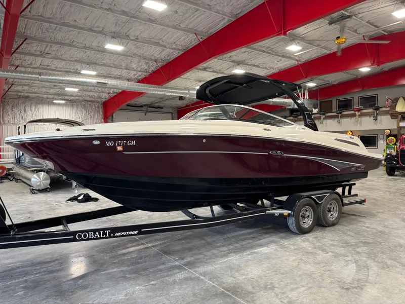 The Image of 2011 Sea Ray 250 SLX boat on trailer in indoor storage facility. - 1